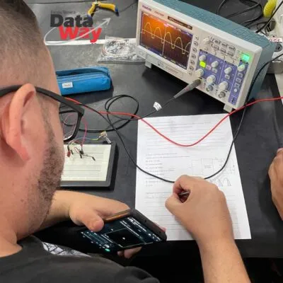 Aluno fazendo anotações em aula prática de osciloscópio